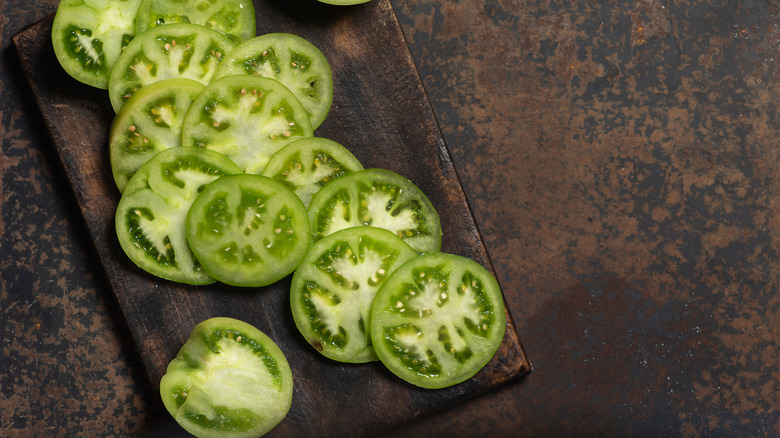 Sliced green tomatoes on a cutting board