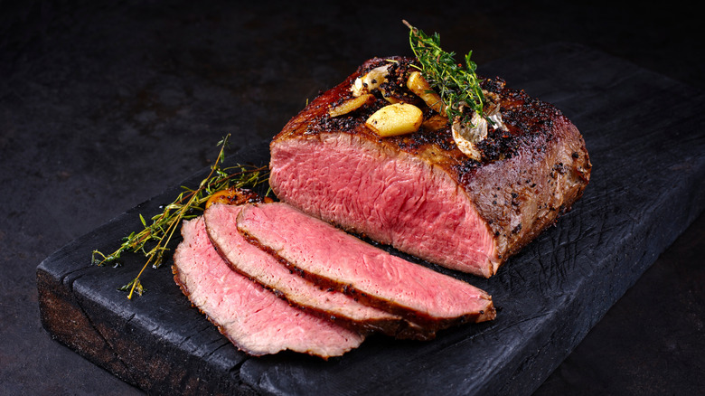 Sliced beef roast on black board