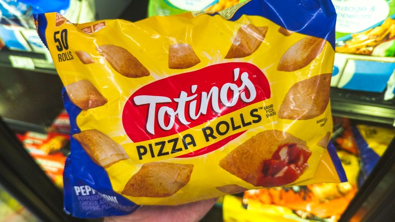 Person holding a bag of Totino's Pizza Rolls in store
