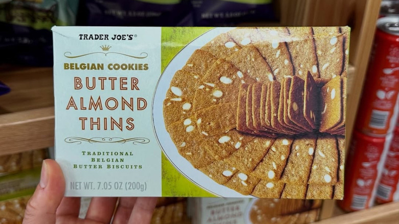 Hand holding box of Trader Joe's Belgian Butter Almond Thins cookies