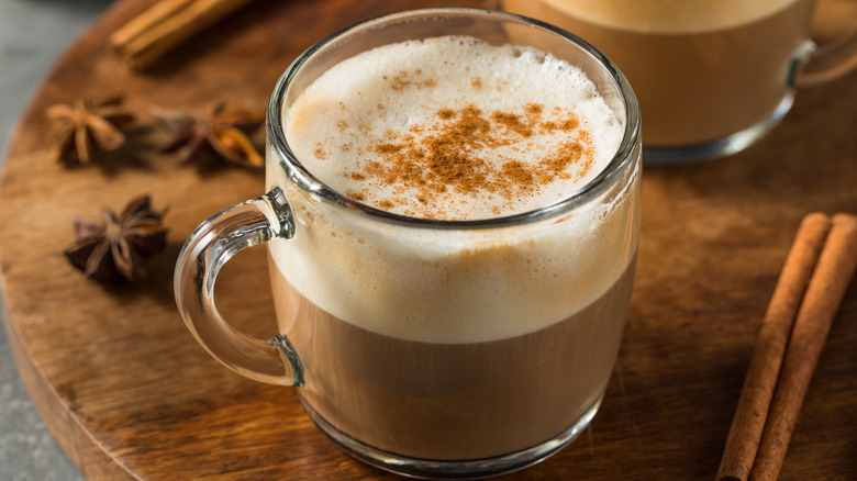 Hot chai latte on a table with anise and cinnamon spices