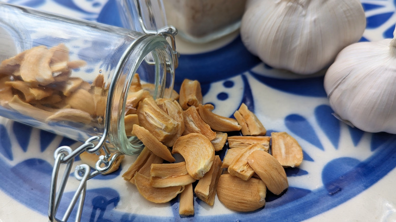 A jar of dehydrated garlic cloves on a blue patterned plate
