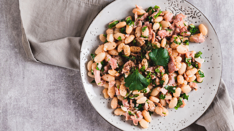 salad with tuna and cannellini beans on a speckled plate