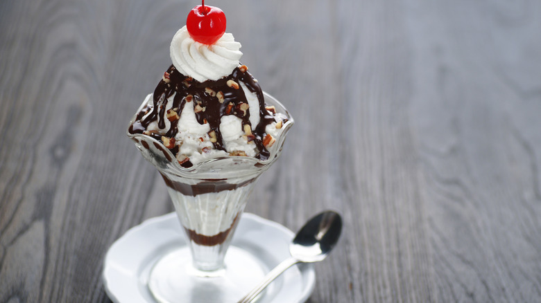 Hot fudge sundae in tall glass with spoon