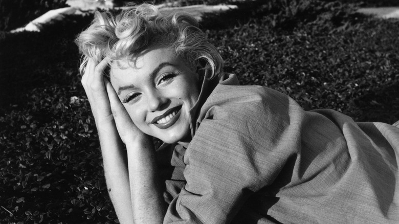 Black and white photo of Marilyn Monroe laying on ground