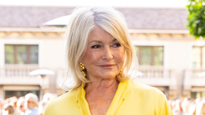 Martha Stewart dressed in a yellow outfit with long, dangling earrings.