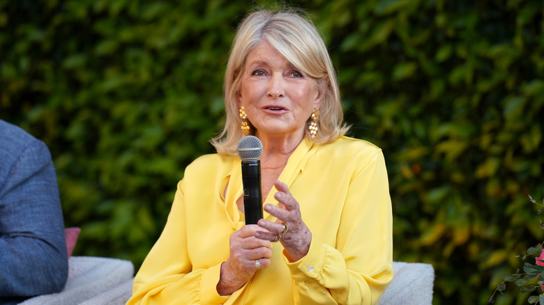 Martha Stewart in yellow speaks with microphone