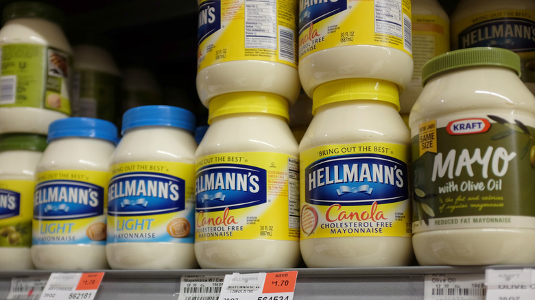 A store shelf with several brands of mayonnaise