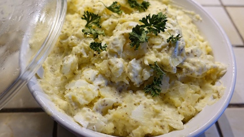 Potato salad in bowl on tiled table