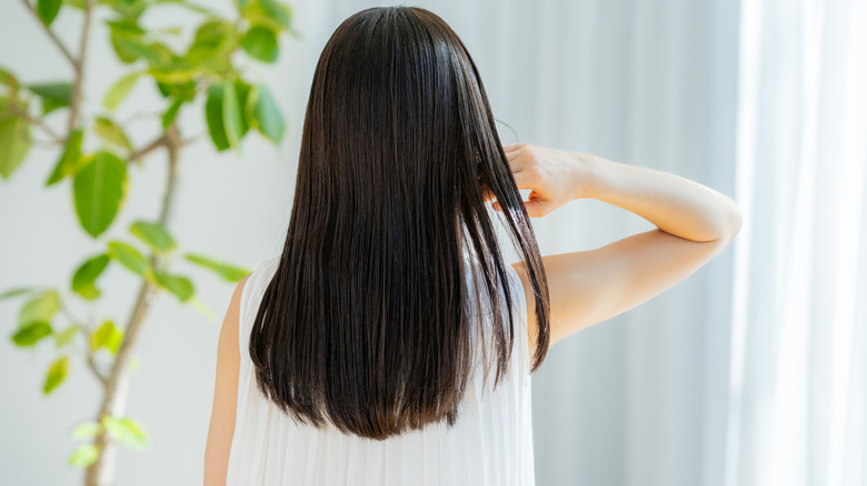 Woman touching her long dark hair