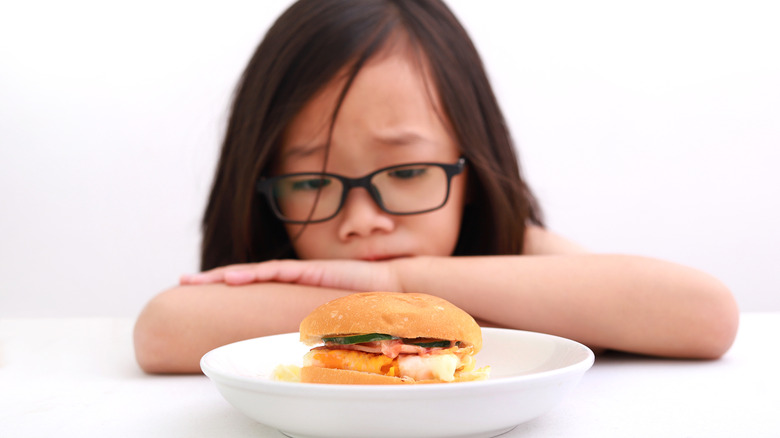 A child grossed out by a sandwich with a dollop of mayonnaise