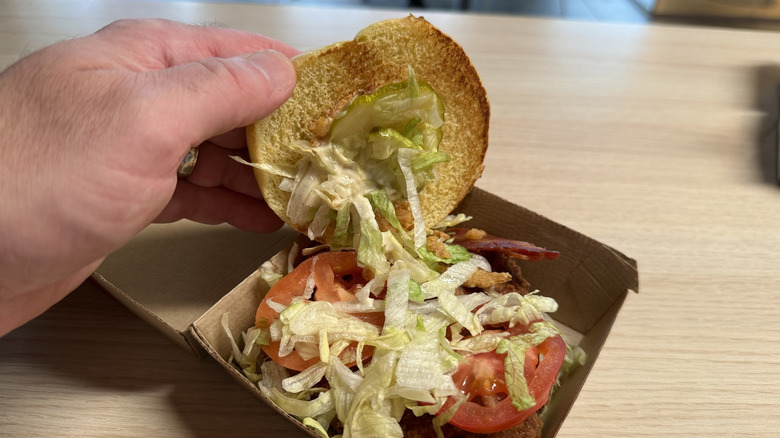 The lid being lifted off a Bacon Caesar McCrispy Sandwich