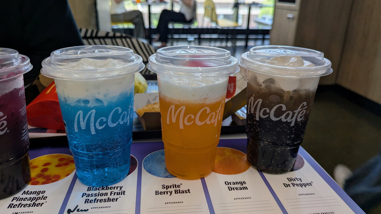 McDonald's Crafted Sodas on a table, including Sprite Berry Blast, Orange Dream, and Dirty Doctor Pepper.