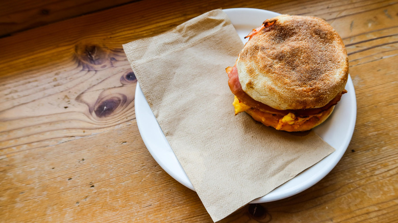An egg McMuffin on a plate with a paper napkin