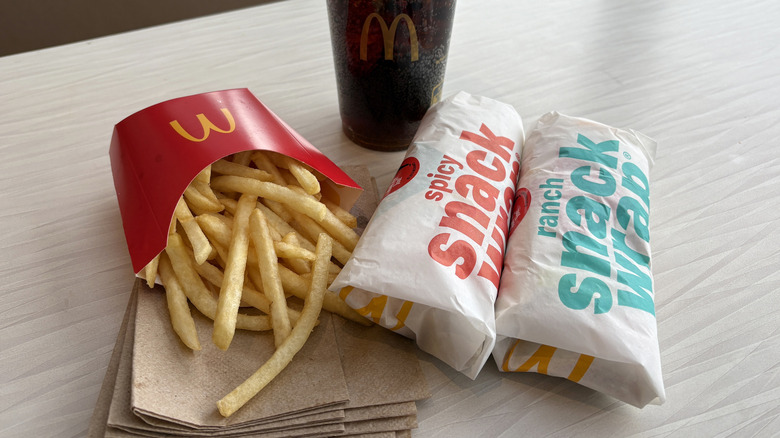 Two McDonald's Snack Wraps with fries and a drink on a table at McDonald's.