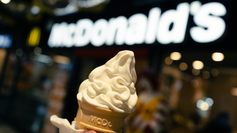 Mcdonald's soft serve ice cream cone in front of McDonald's sign
