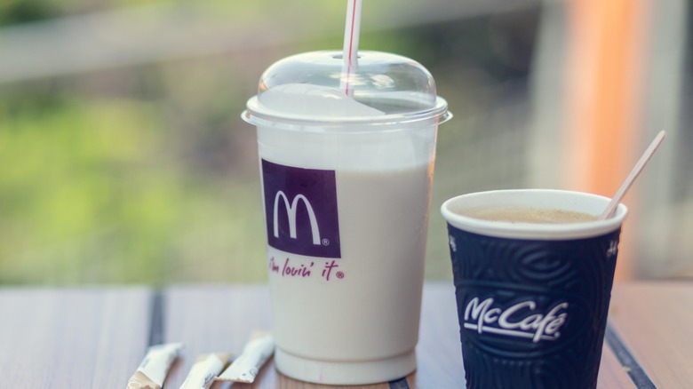 A McDonald's shake next to a cup of McDonald's coffee.