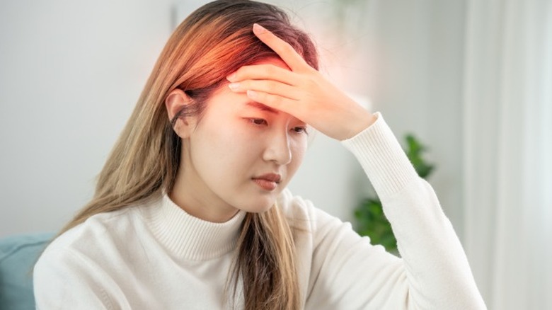 A woman with a migraine, represented by an "aura" around her head.