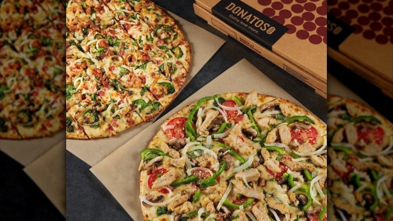 Two pizzas from Donatos with box in the background.