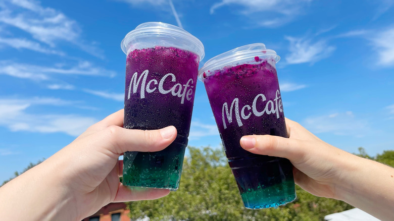 Two McDonald's Red Bull Dragonberry Energizers held up to a blue sky