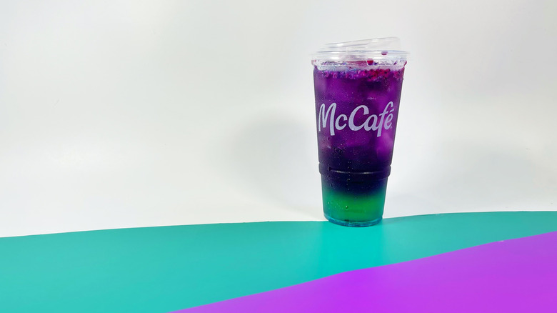 A Red Bull Dragonberry Energizer on a white backdrop with stripes of teal and purple