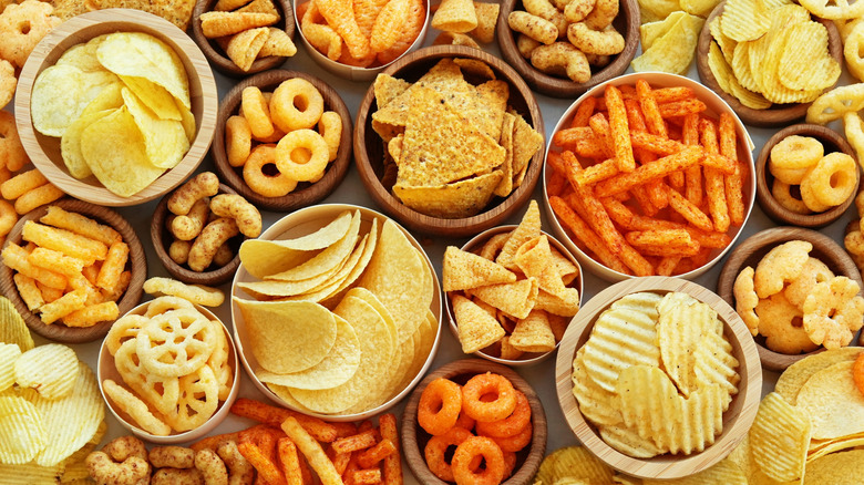 bowls of chips, cheese puffs, and other salty snacks