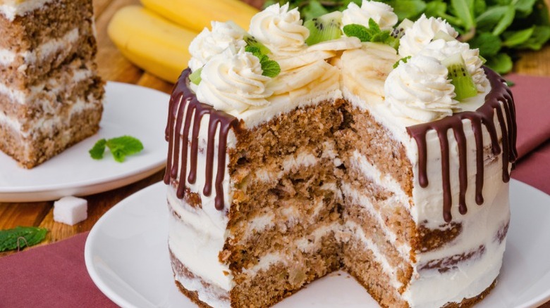 Hummingbird cake with a slice removed and placed near it on a plate