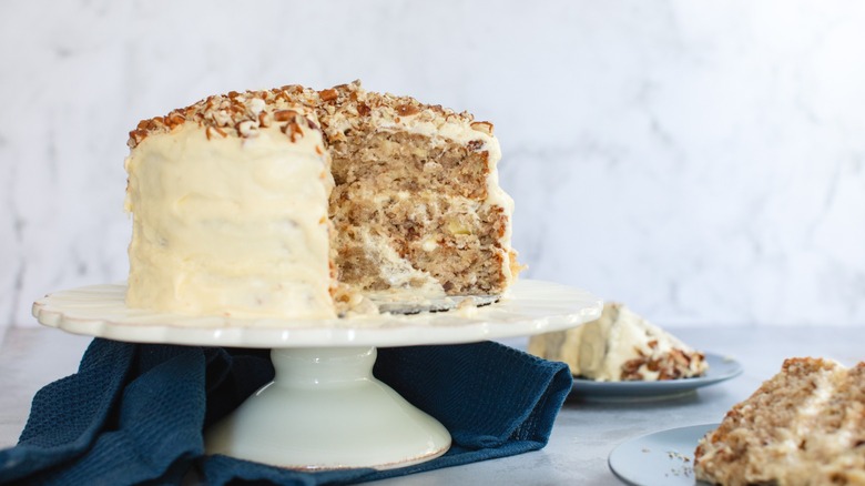 A three-tier hummingbird cake next to slices on plates