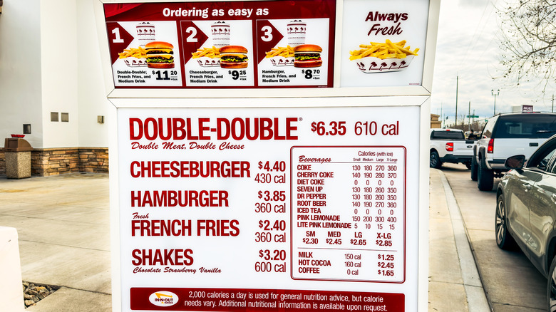 The In-N-Out drive-thru menu with cars in a line.