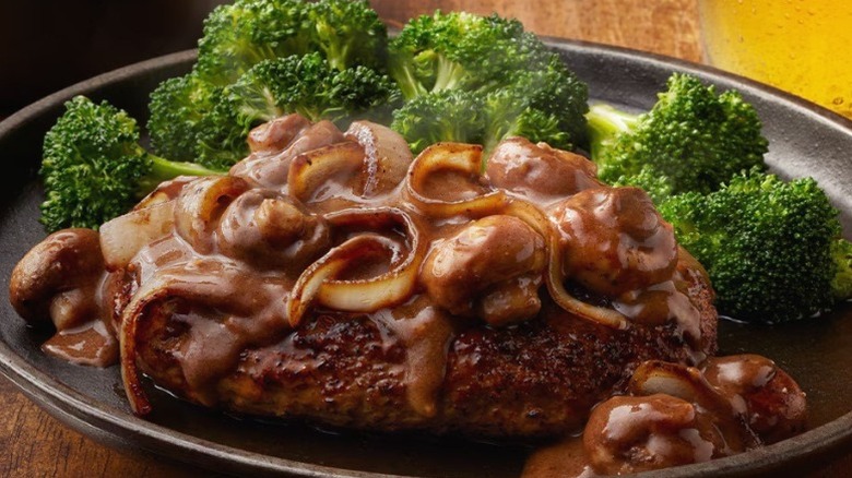 A picture of LongHorn Steakhouse's Chop Steak on a black plate.