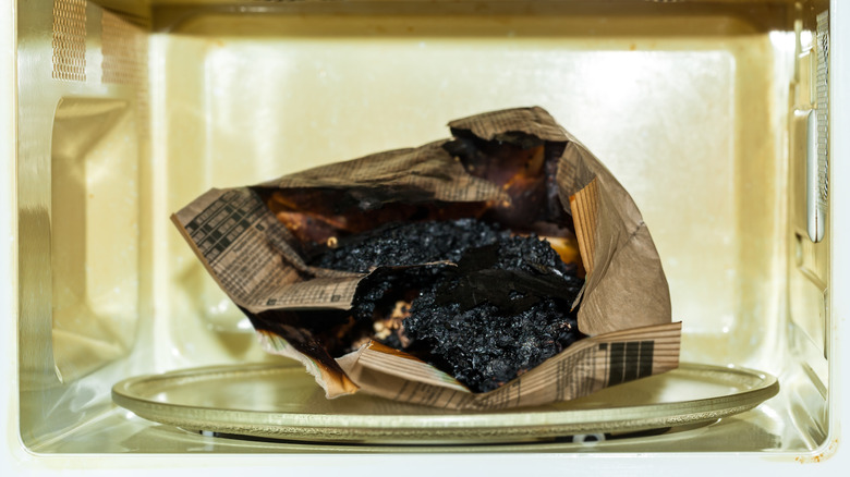 bag of utterly scorched popcorn inside microwave