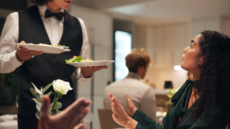 Anger, food and unhappy woman in restaurant for hospitality or service disappointment.