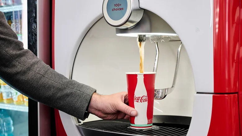 hand getting soda from Coca-Cola Freestyle Machine