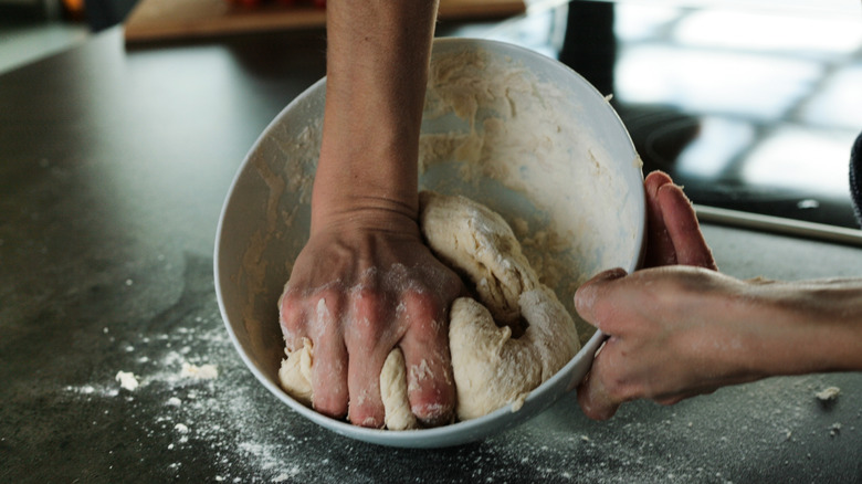 Hands mixing together dough