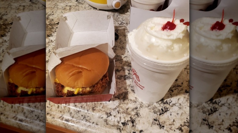 Chick-fil-A chicken sandwich and shake with whipped cream and a cherry.