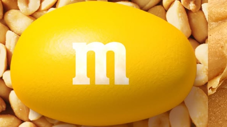 Yellow Peanut M&M's with loose peanuts in background