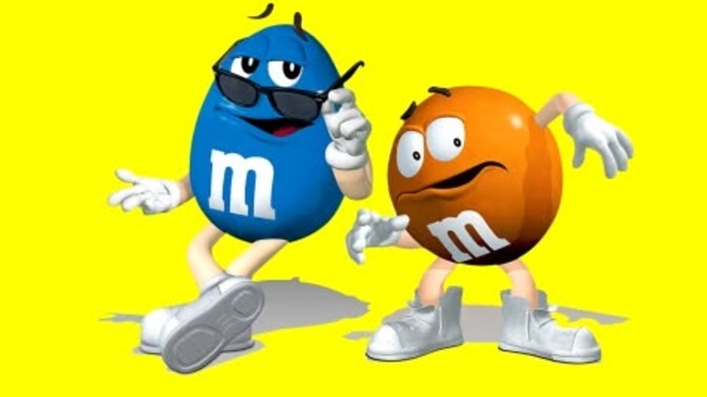 Tan and blue M&M's mascots wityh bright yellow background