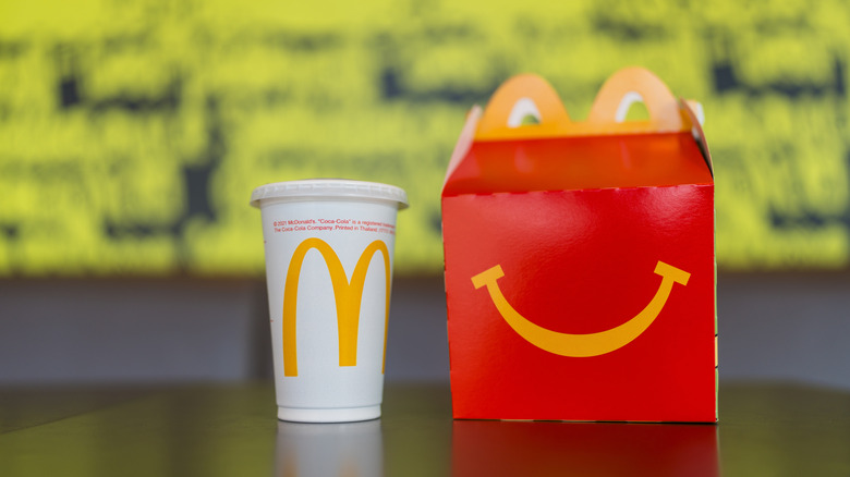 A Happy Meal box and drink from McDonald's sitting on a table