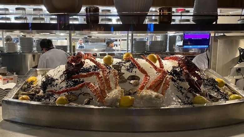King crab and lemons displayed on ice in front of an open kitchen