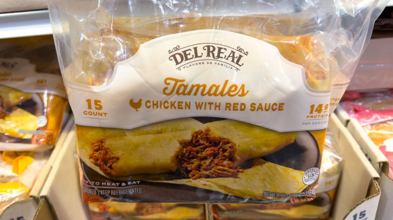 A bag of Del Real tamales rests on a carton full of them in a Costco aisle.