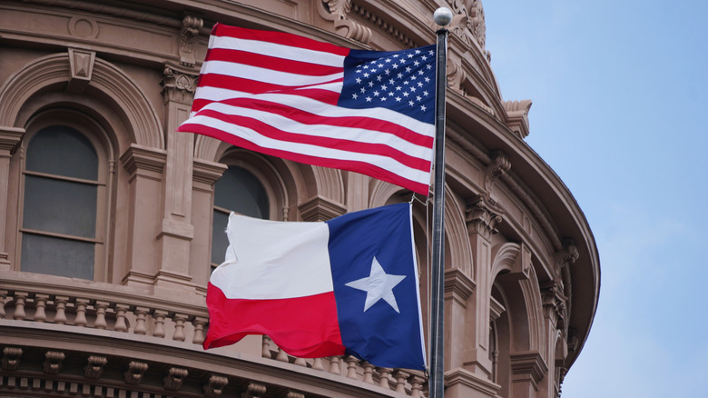 U.S. and Texas flags fly at Texas capitol building