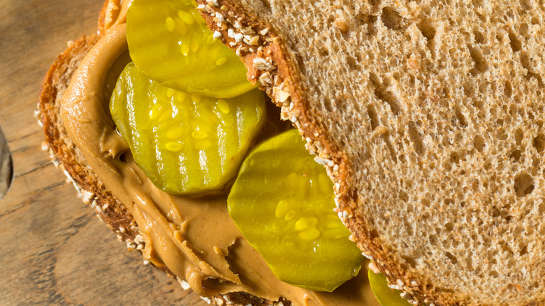 Pickles perfectly spread on peanut butter and multigrain bread