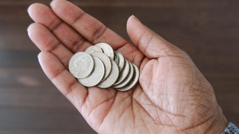 hand holding collection of quarters