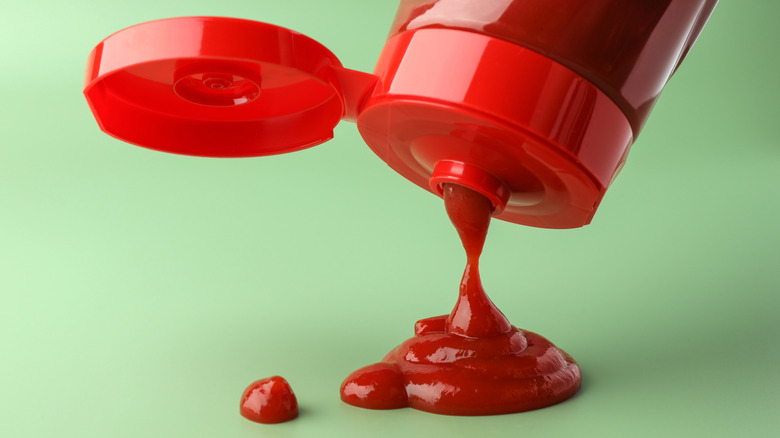 Ketchup squirts out of a red plastic bottle