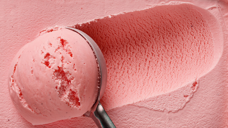 Close-up of ice cream scoop scooping pink ice cream