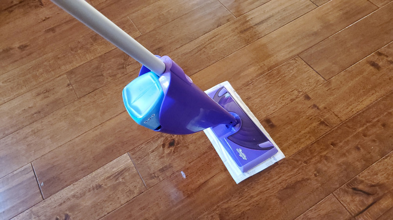 A Swiffer brand WetJet being used on a hardwood floor