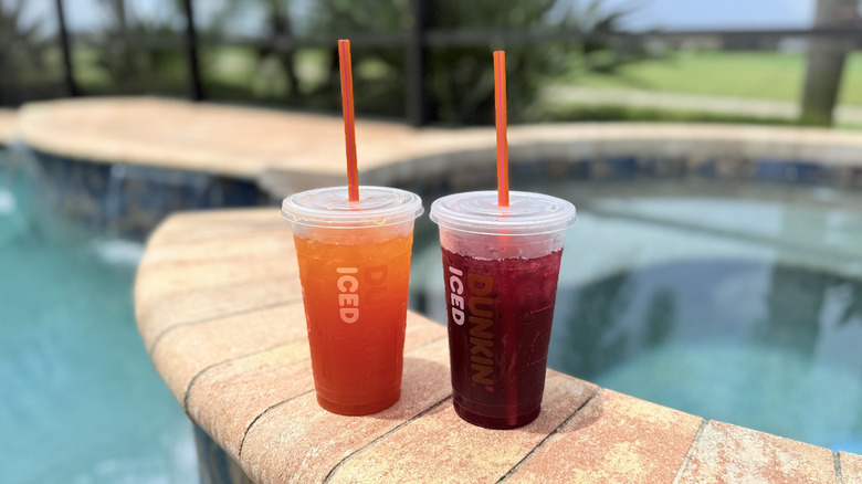 Two Dunkin' Refreshers with a pool in the background