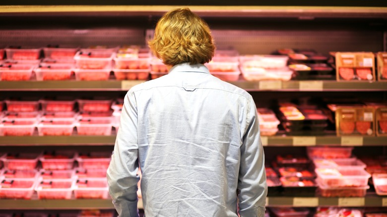 Person looking at meat in grocery store
