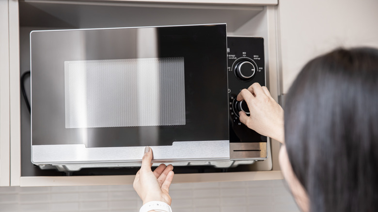 woman opening a microwave oven