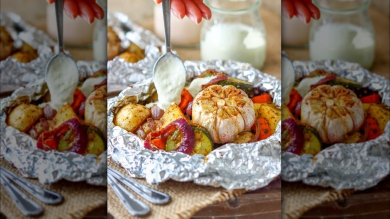 foil packet of vegetables with some type of white sauce